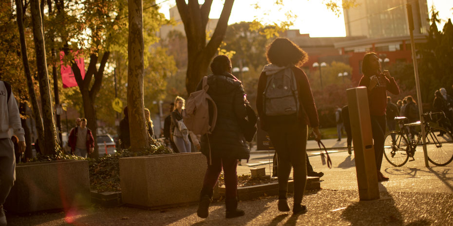 Students walking on Main Campus at dusk on a fall day