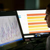 Student viewing two monitors showing graphical data