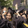 Students taking off graduation caps in regalia at Commencement