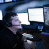 Safety officer viewing computer monitors with headset