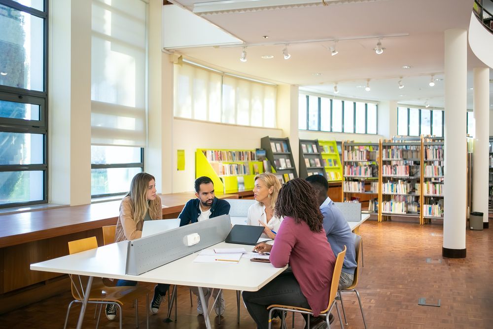 Students discussing around table in library
